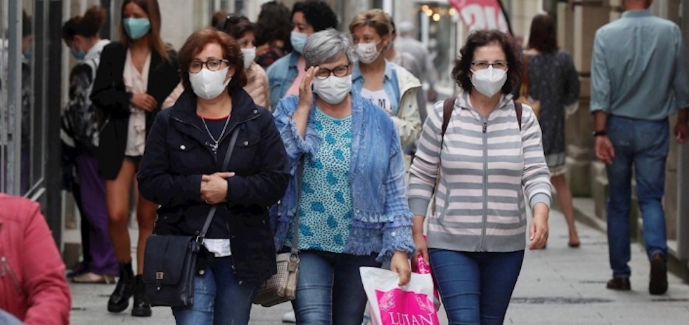 Varias personas con mascarilla caminan por la calle. EFE