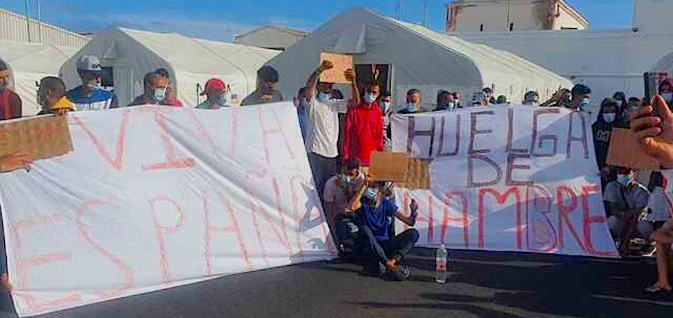 Migrantes alojados en el 'Canarias 50' con pancartas reivindicativas. / El Español