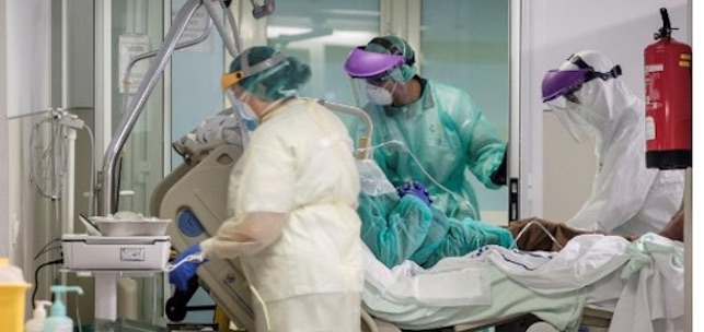 Tres sanitarios trasladan a un paciente con Covid 19 por los nuevos circuitos acotados por mamparas de protección y estructuras de aluminio para redistribuir los espacios, con áreas delimitadas y blindadas ante el contagio. EFE/Ángel 