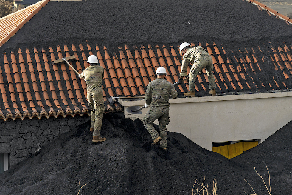 Retirada de cenizas del volcán en el tejado de una casa. Imagen de archivo