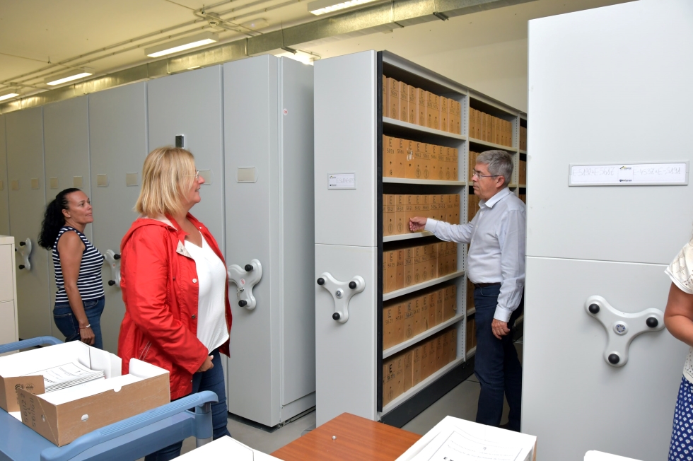 Miembros del grupo de gobierno observando la clasificación de las cajas de expedientes en el interior de uno de los pasillos de los nuevos módulos herméticos