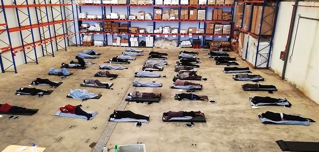 Migrantes llegados a Gran Canaria que pasaron los primeros tres días de su cuarentena pernoctando en el suelo de un almacén portuario | Efe