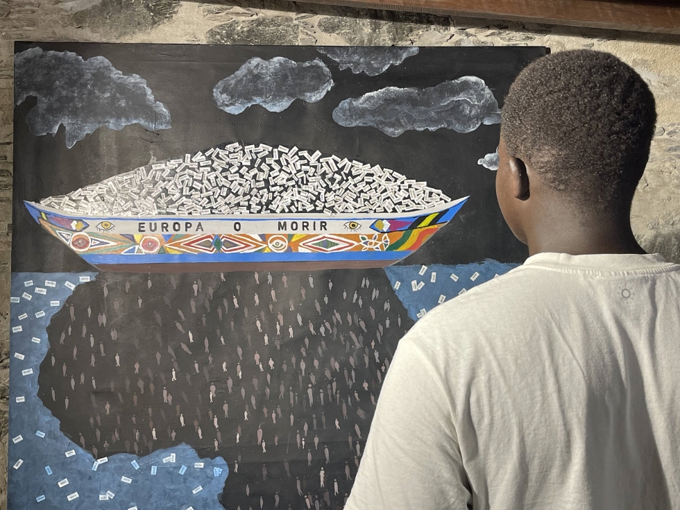 Dieng Mbaye frente a una de las obras de la exposición