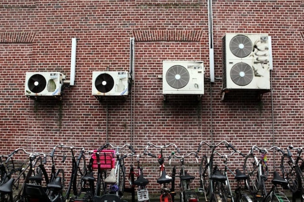 Los aparatos de aire acondicionado pueden enfriar una vivienda o un negocio, pero también calientan el aire del exterior y, por tanto, el ambiente de las ciudades. Joost J. Bakker/Flickr, CC BY-NC