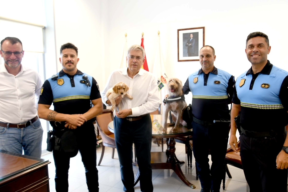 El alcalde. con la cachorra Moka y junto a la perra Peka, con el oficial y el agente de la unidad canina, el comisario jefe y el concejal de Seguridad y Emergencias