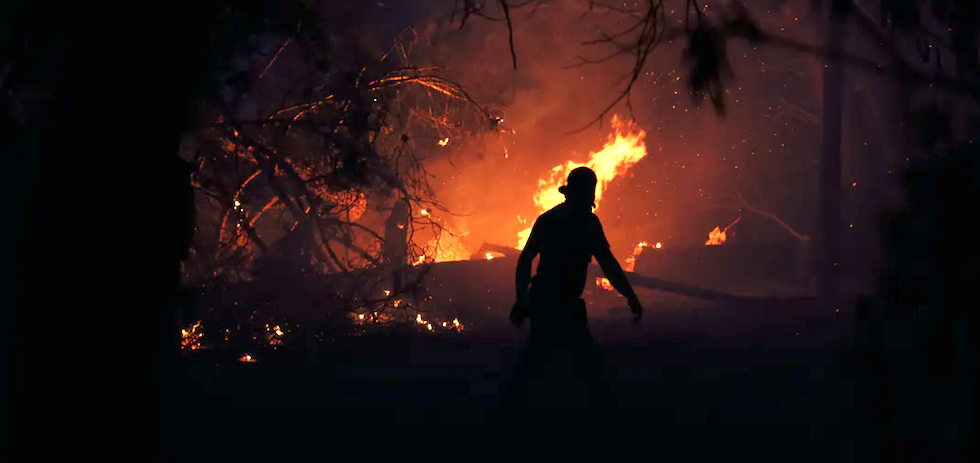 Un vecino ante el incendio declarado en Varympompi, al norte de Atenas (Grecia), el 3 de agosto de 2021. Shutterstock / Alexandros Michailidis
