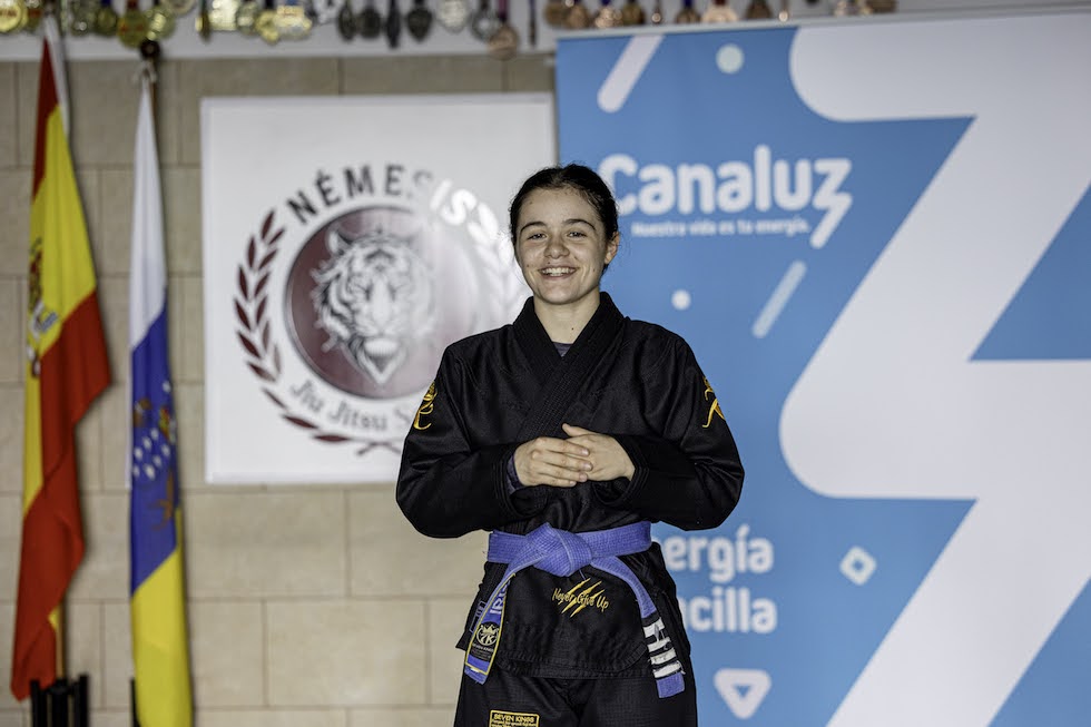 La medallista mundial, Iris García, joven promesa del Grappling español, posa en su gimnasio junto a la marca Canaluz y el escudo del Team Némesis. | FOTO: MARCOS DE RADA.
