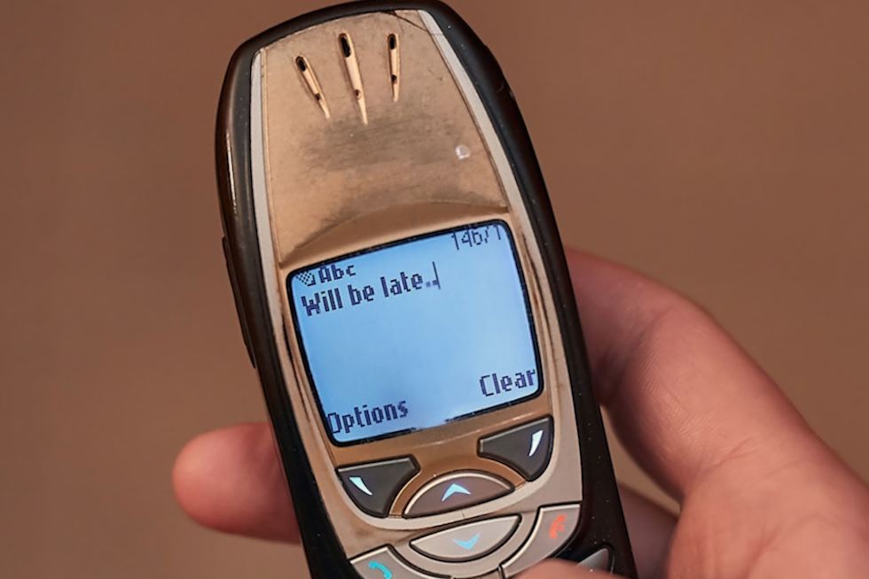 Un usuario escribe un SMS en un modelo antiguo de m&oacute;vil. Desintegrator/Shutterstock